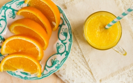 pomarancovy dzus v pohary a platky pomaranca na tanieriku