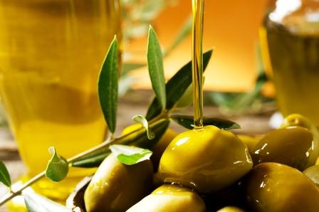 olivový olej lející se na olivy
