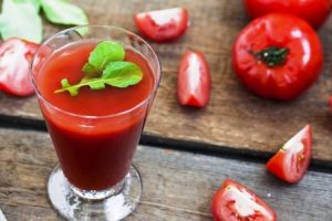 paradajkove smoothie v sklenenom pohári na stole s rukolou