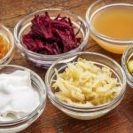fermentované potraviny v miskách - jablční ocet, okurka, řepa, zelí