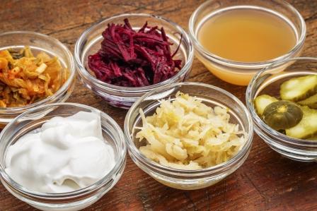 fermentované potraviny v miskách - jablční ocet, okurka, řepa, zelí
