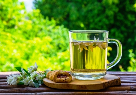Sklenené šálky bylinného čaje jasmínového čaje a jazmínových květů